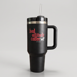 A matte black insulated travel tumbler with a handle, lid, and straw, featuring the red and white text 'bad attitude coffee' on the front, set against a neutral gray background.